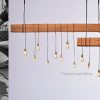 rustic bare wood pendant lamp with edison bulbs and brass fittings by piment rouge lighting bali